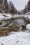 Winter landscape. Mountain river flows from the rocks. Snow and mountain river