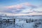 Winter landscape with old wood fence, windmills and sunset clouds