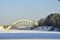 Winter landscape. Railway bridge over the frozen river.