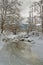 Winter landscape with a river covered with ice in a cloudy day