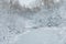 Winter landscape with a river covered with ice and a forest under the snow.