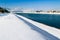 Winter landscape. River flows through city covered with snow