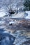 Winter landscape, river under the ice and snow, and tree branches covered with white frost