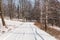 Winter landscape with road forest and blue sky. Wintry path. Frosty sunny day. Snowy winterly landscape.