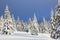 Winter landscape. On the road on the lawn the man stands and photographers the mountains and forest. Pine trees.