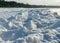 Winter landscape by the sea, snowy, interesting ice shapes on the sea shore, dunes covered with a white layer of shining snow