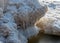 Winter landscape by the sea, snowy, interesting ice shapes on the sea shore, dunes covered with a white layer of shining snow