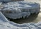 Winter landscape by the sea, snowy, interesting ice shapes on the sea shore, dunes covered with a white layer of shining snow