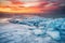 Winter landscape on seashore during sunset. Lofoten islands, Norway. Ice and sunset sky.