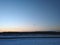 Winter landscape in silhouette of a skydiver with a parachute at sunset