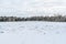 The Winter landscape. Snow-covered field and forest on the horizon on a clear winter day. Nature of Russia in winter. White drifts