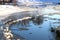 Winter landscape. Snow-covered shoreline with reflection of trees in the river