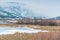 Winter landscape of snow covered wetland habitat with mountains and fog