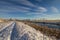 Winter landscape with snow, river, common reed, blue sky, road , sunshine. Norway