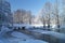 Winter landscape with stream and footbridge in rural terrain