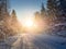 Winter landscape with sunbeams, forest and road