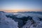 Winter landscape at sunrise from Velky Choc mountain in winter with fog in valley, view of low and high Tatras and Liptovska Mara