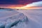 Winter landscape in sunset, Cracked frozen lake covered of snow at lake Baikal in Russia with beautiful sunset sky