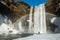 Winter landscape, tourist by famous Skogafoss waterfall with rainbow, Iceland