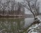 Winter landscape of Ukrina river, snowy banks and naked trees in riparian zone