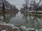 Winter landscape of Ukrina river, snowy banks and naked trees in riparian zone