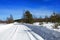 Winter landscape. View of snow-covered trees, snowdrifts and road in the countryside in winter on a frosty Sunny day. Russian