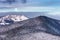 Winter landscape - view of the snowy forested mountains in the evening under the moon