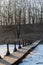 Winter landscape with a wooden bridge crossing a lake surrounded by reeds