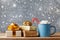 Winter lifestyle with cup of hot cocoa with marshmallows and Christmas gift or present boxes on wooden background. Snow effect