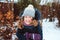 Winter lifestyle portrait of happy kid girl playing snowballs on the walk