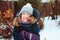 Winter lifestyle portrait of happy kid girl playing snowballs on the walk