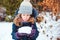 Winter lifestyle portrait of happy kid girl playing snowballs on the walk