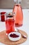 Winter lingonberry drink and frozen lingonberries on white table. Healthy vitamin drink