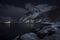 Winter Magic: A Quaint Village Nestled Along a Snow-Covered Fjord Shoreline, Illuminated by Night Lights, ai generative