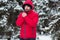 Winter male portrait. Young bearded man trying to heat his cold hands in frost winter park. Cold season concept