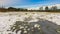 Winter meadows with snow and frozen puddle