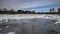 Winter meadows with snow and frozen puddle