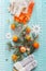 Winter mood composing with tangerines, orange sweater, funny socks and fir branches on blue knitted blanket with snowflakes. Top