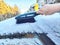 Winter Morning Car Snow Clearing. Hand of Woman person brushing snow off car on a frosty winter morning. Difficulties in