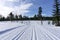 Winter mountain landscape with groomed ski track and blue sky in sunny day.