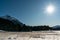 Winter mountain landscape with snowy mountain peaks and a frozen lake and marsh grass in the foreground