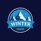 Winter mountain with snowy peak and snowfall in round. Snowy mountain landscape in winter season. Badge for company