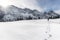 Winter mountains and man walking through snow. Footsteps in snow