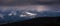 Winter mountains panorama with dramatic storm clouds, light in the dark shining on the snow mountain. Yunnan, South China