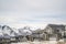 Winter neighborhood with homes viewed against snowy mountain and cloudy sky