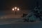 Winter night city Saratov quay bund under snowfall. Street decorative lights in night cityscape