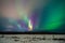 Winter night landscape with forest, road and polar light over the trees.