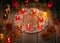 Winter ornamental decoration with burning candles on wooden rustic table with mulled wine punch and gingerbread.