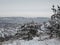 Winter panorama of the frozen river and the city embankment. The weather is cloudy and frosty. Much snow