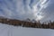Winter panorama with small winter hut almost completely buried by snow